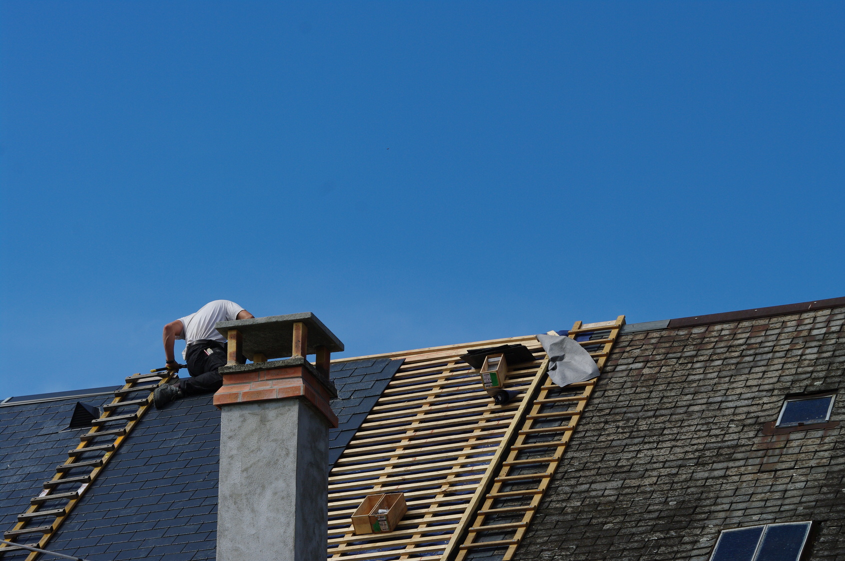 Couvreur zingueur sur le toit d'une maison