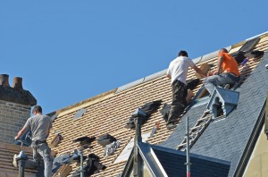 Plusieurs couvreurs sur le toit d'une maison