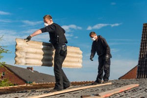 Artisans rénovant toiture.