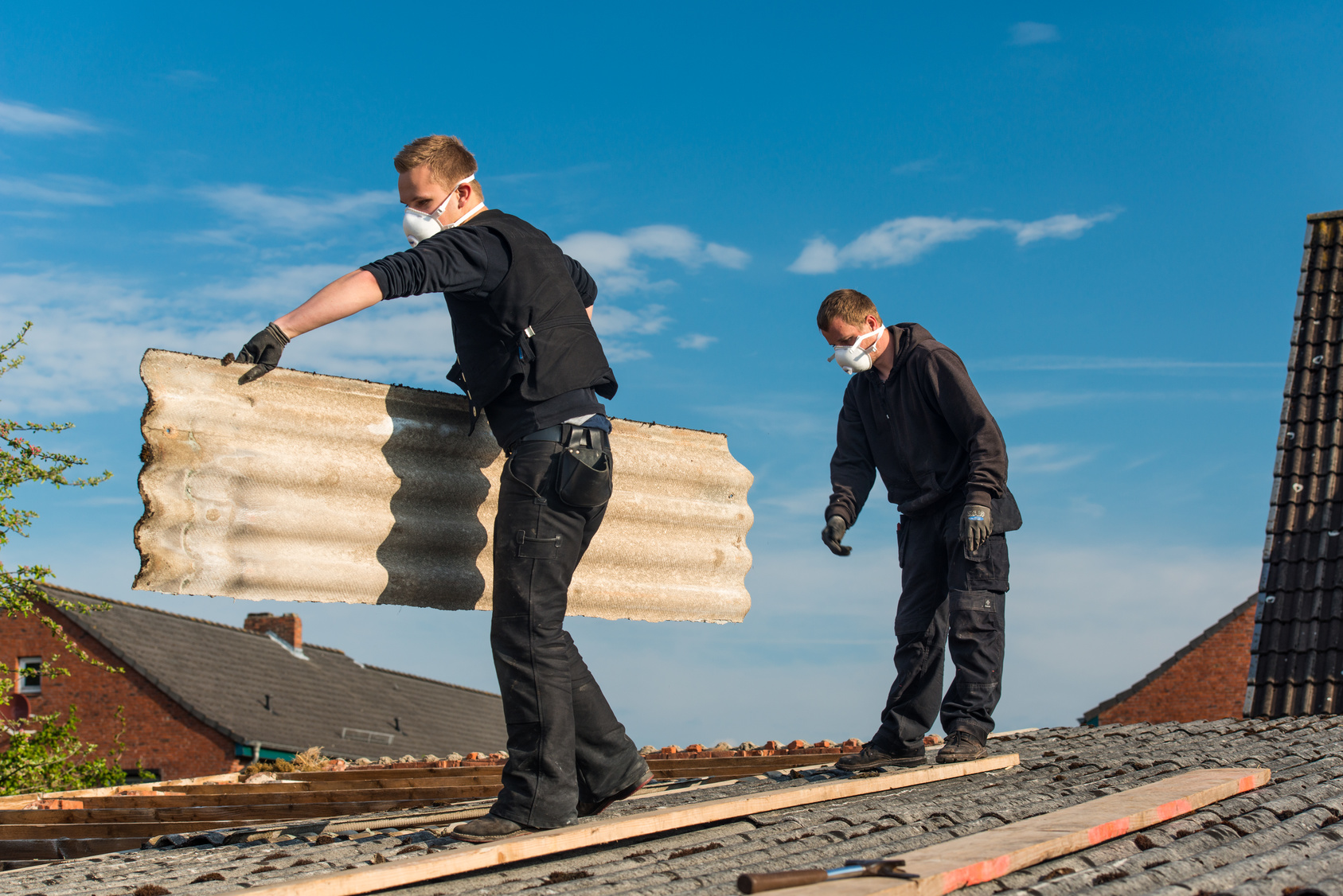 Artisans rénovant toiture.